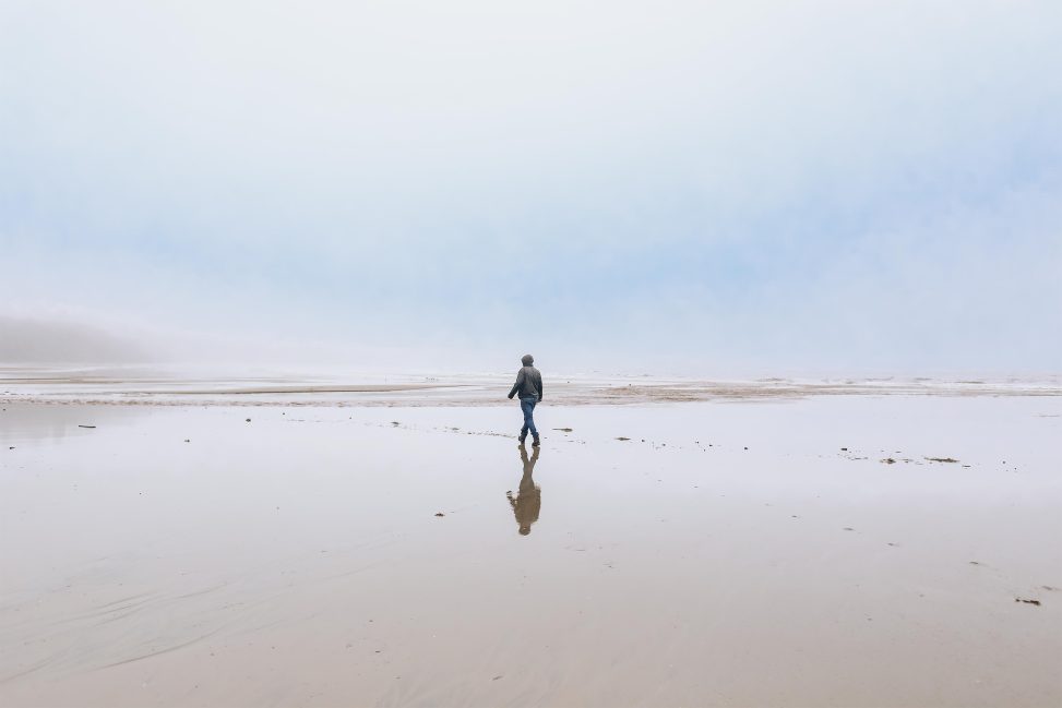 A man walking alongside the beach in Bournemouth